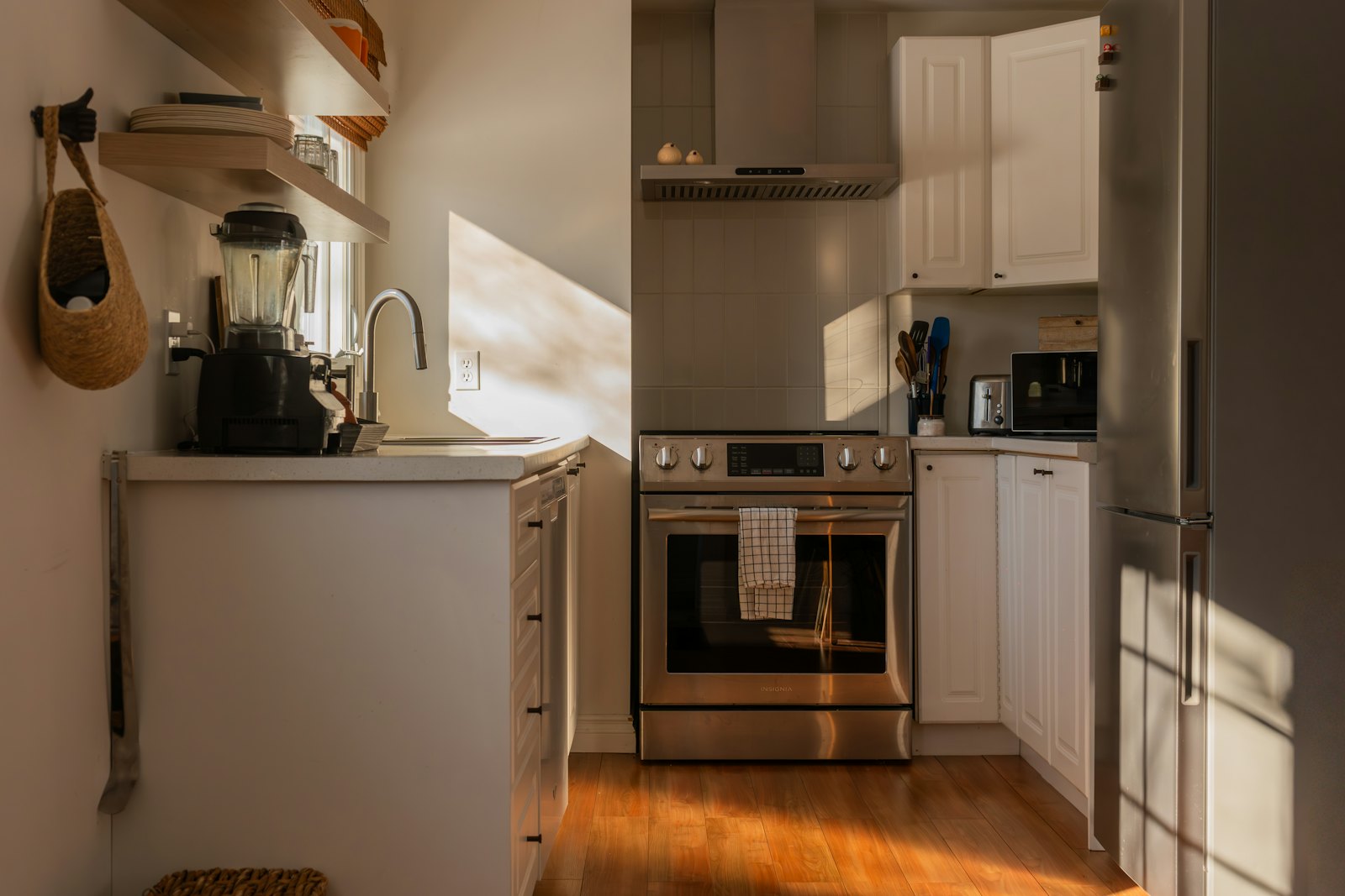 A modern kitchen with stainless steel appliances and wooden floors